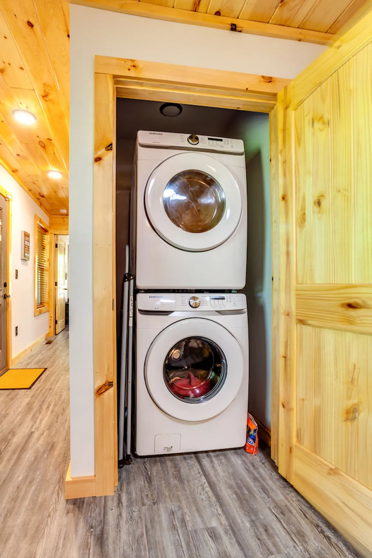 A practical laundry area with a stacked washer and dryer, surrounded by light wooden finishes and a clean, efficient layout. Perfect for taking care of everyday needs during a longer stay.